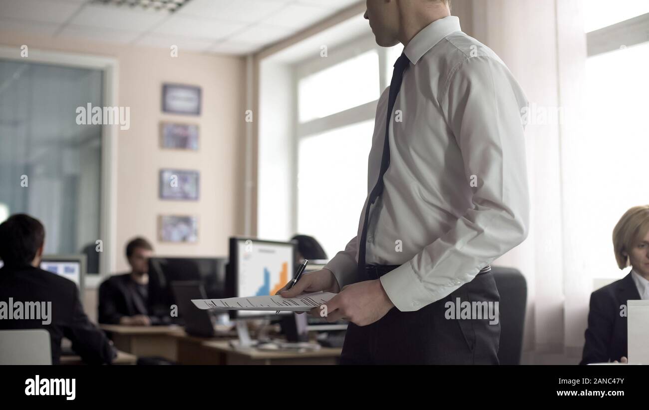 Male recruit holding documents and looking for coach in office, job application Stock Photo