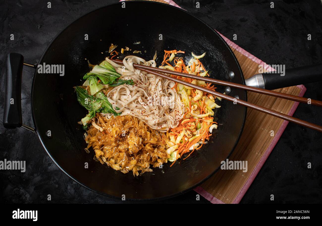 Vegan stir fry consisting of yuba, carrot, bok choy and noodles, served