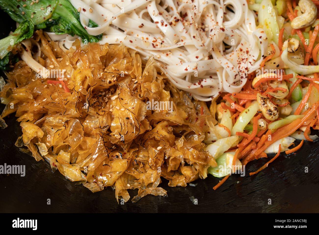 Vegan stir fry consisting of yuba, carrot, bok choy and noodles, served