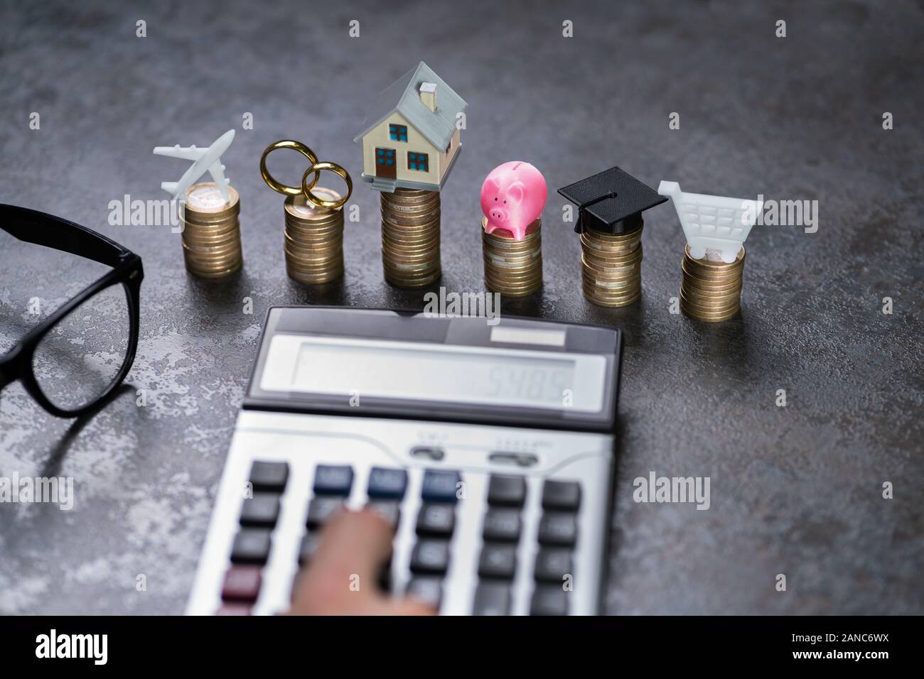 Man Calculating Expenses In Front Of Stacked Coins At Desk Stock Photo ...