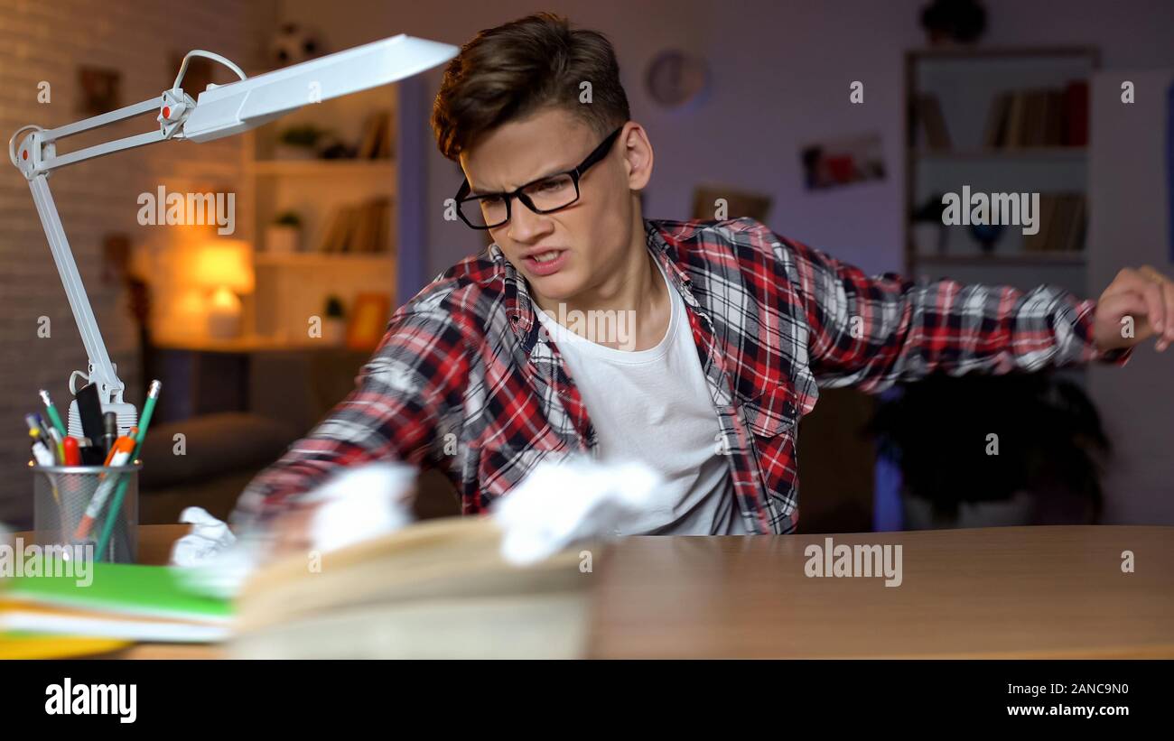 Overloaded aggressive student throwing books of table, cannot solve