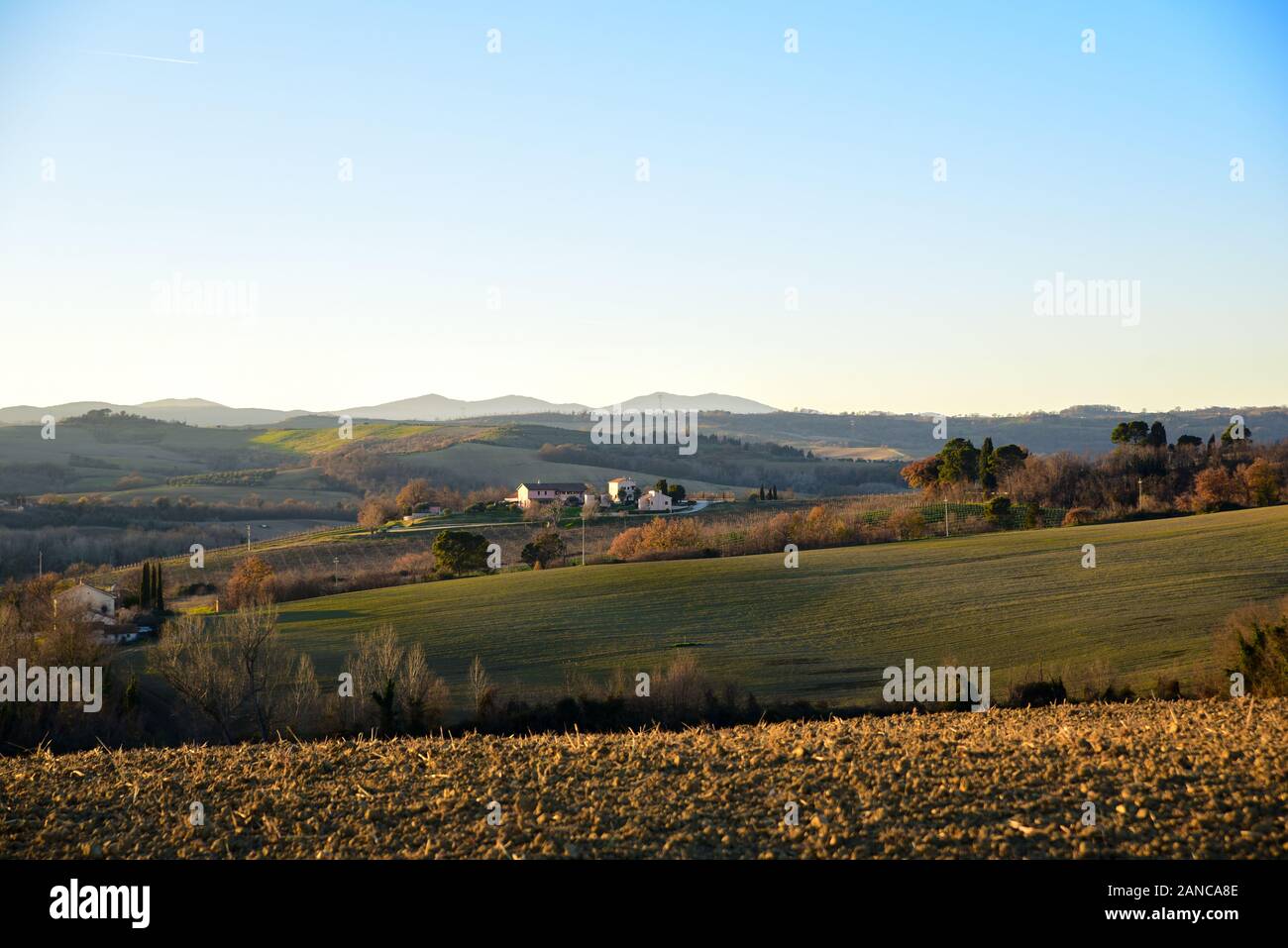 farm in the hills in the warm light of sunset. Countryside and agriculture in winter Stock Photo