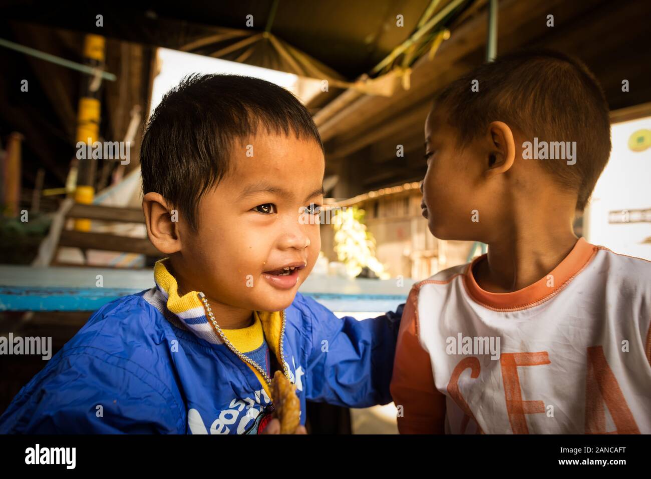 Khlong Toei slums in Bangkok, Thailand: portrait of 2 boys playing and having fun under the highway road. Stock Photo