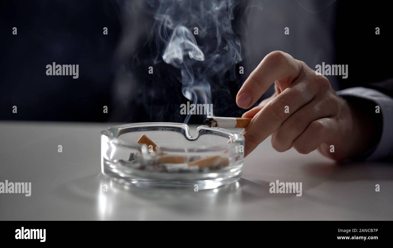 Manager smoking cigarette isolated on dark background, stressful serious job Stock Photo