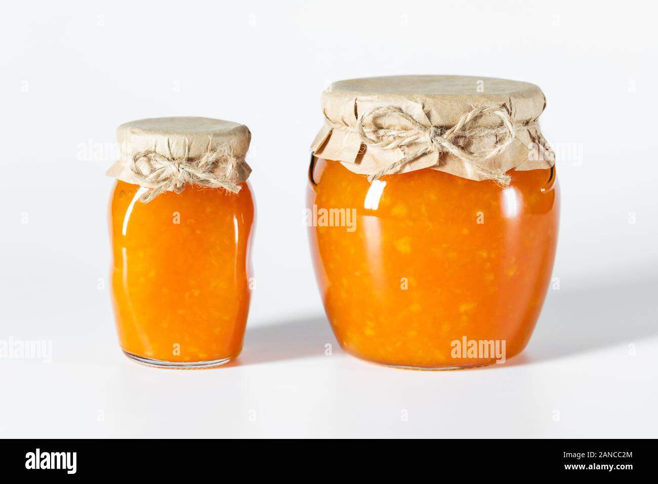 Delicious homemade jam in glass jars on a white background. Side view