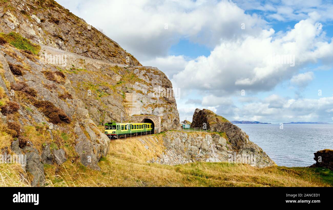 Train exiting a tunnel. View from Cliff Walk Bray to Greystones with beautiful coastline, cliffs