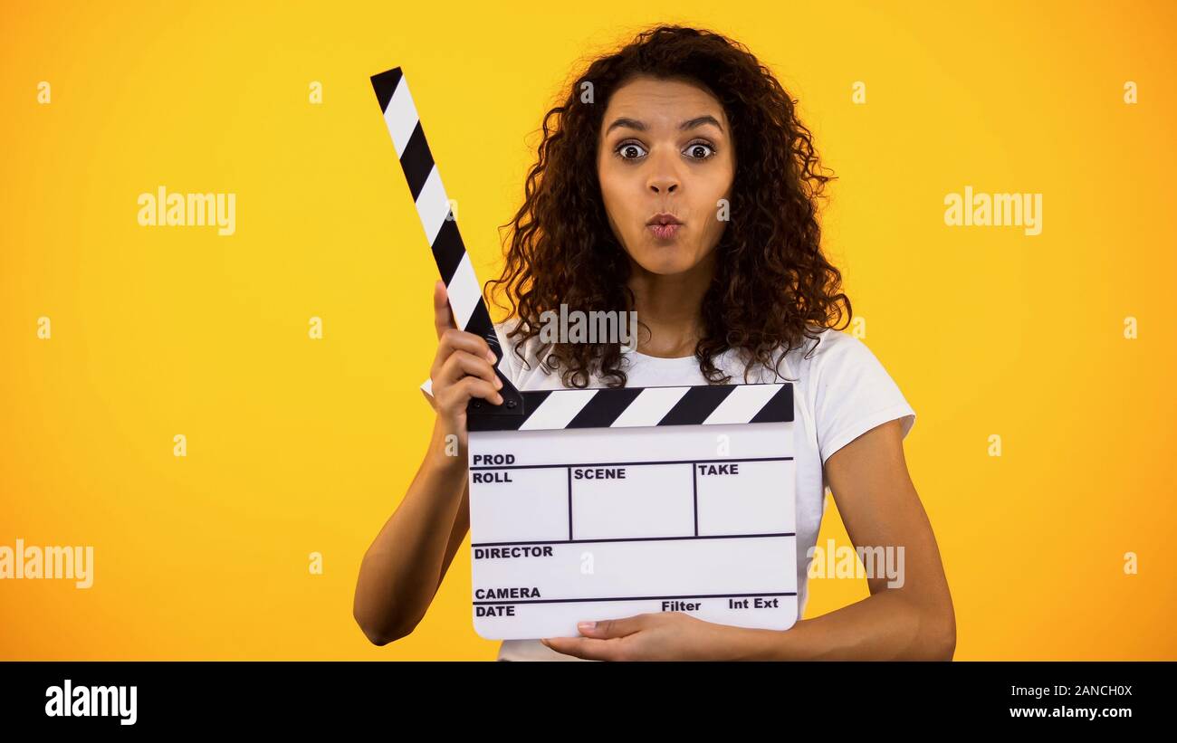 Shocked producer assistant holding clapper board, shooting movie film production Stock Photo