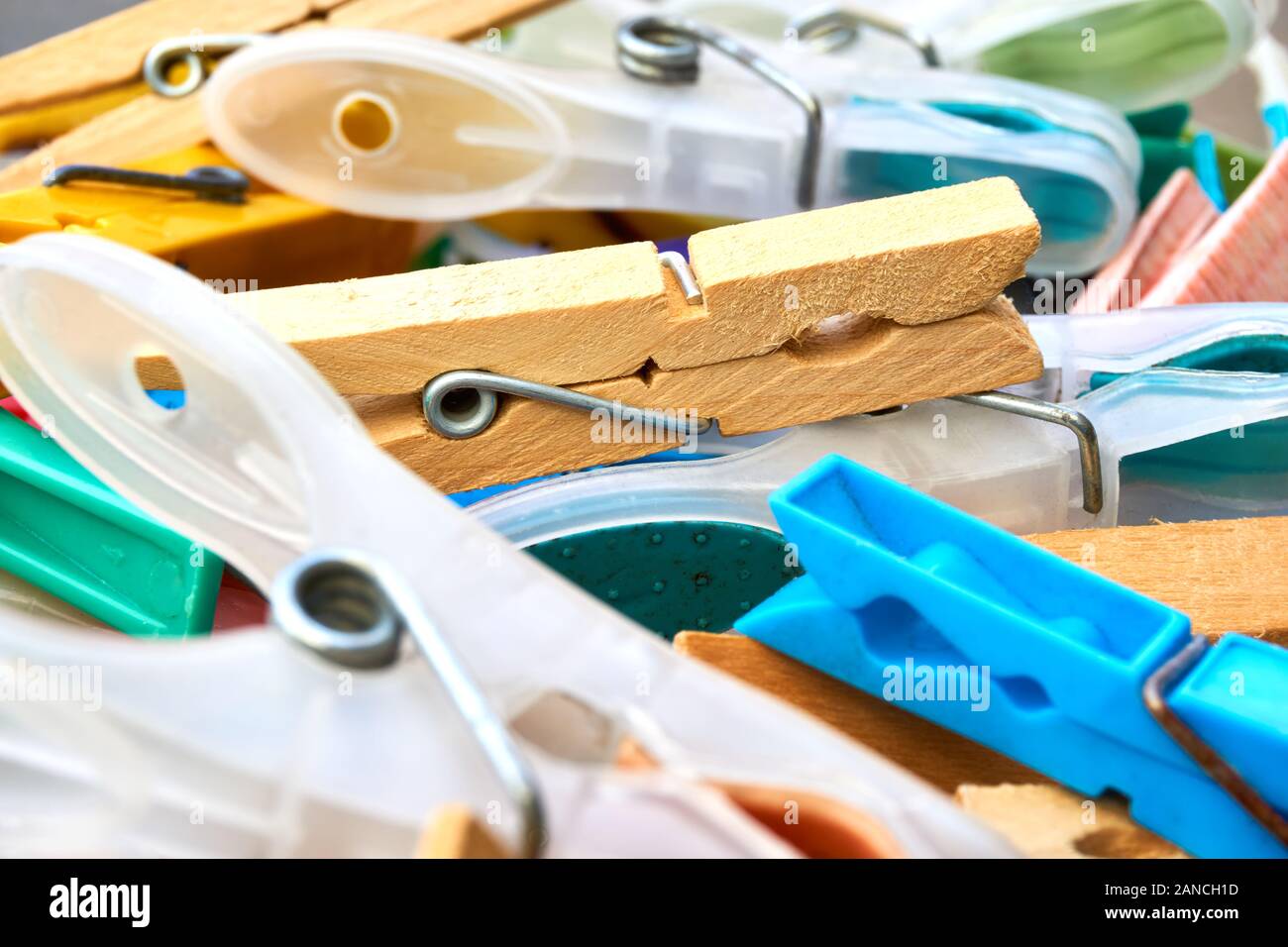 Closeup of plastic and wooden clothespins in a basket in colors yellow, red, green, purple and blue. Concept for washing and monday blues Stock Photo