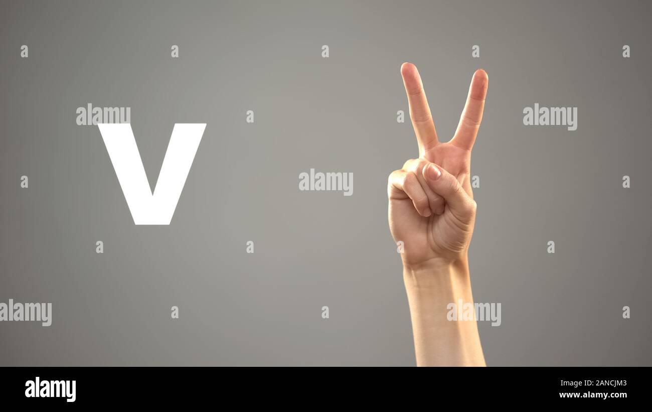 Letter V in sign language, hand on background, communication for deaf