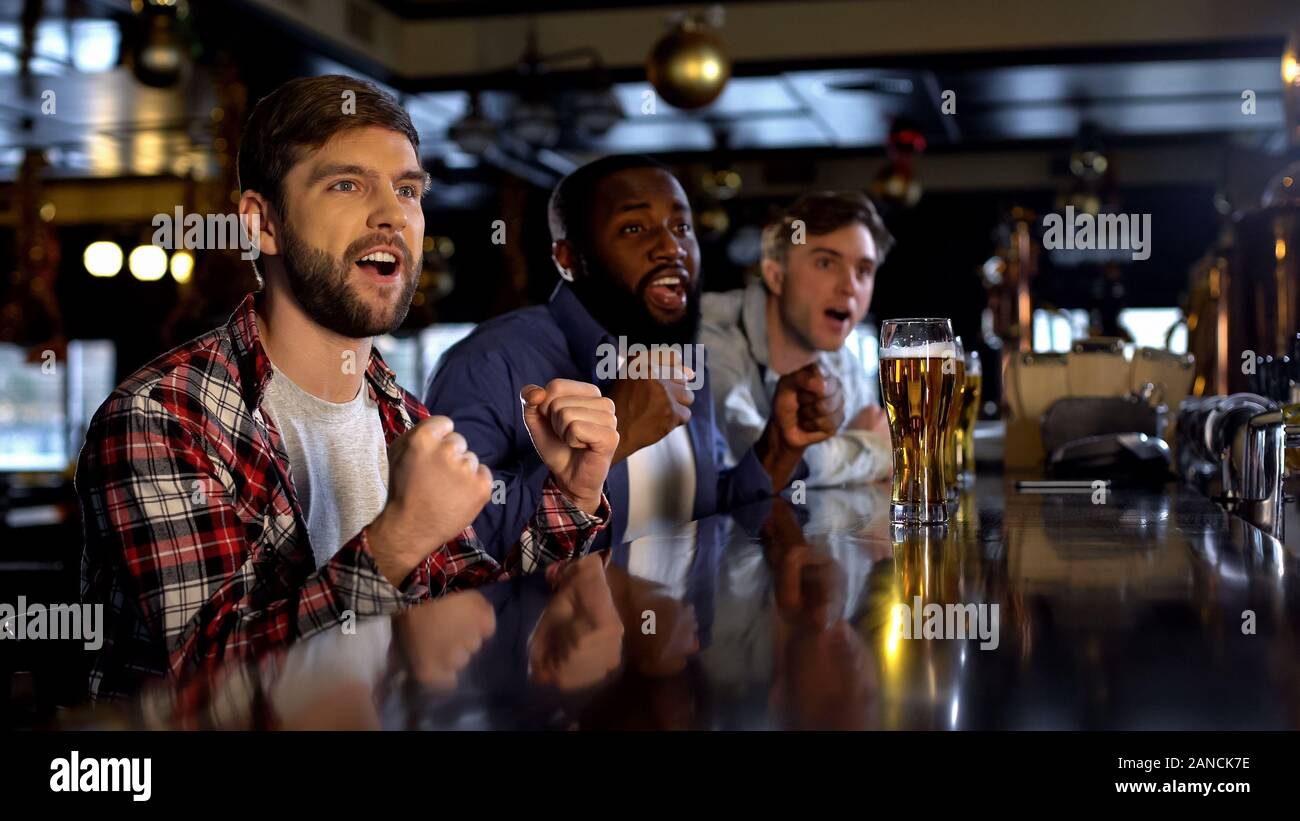 Happy sport fans watching tournament in pub, cheering for favorite team