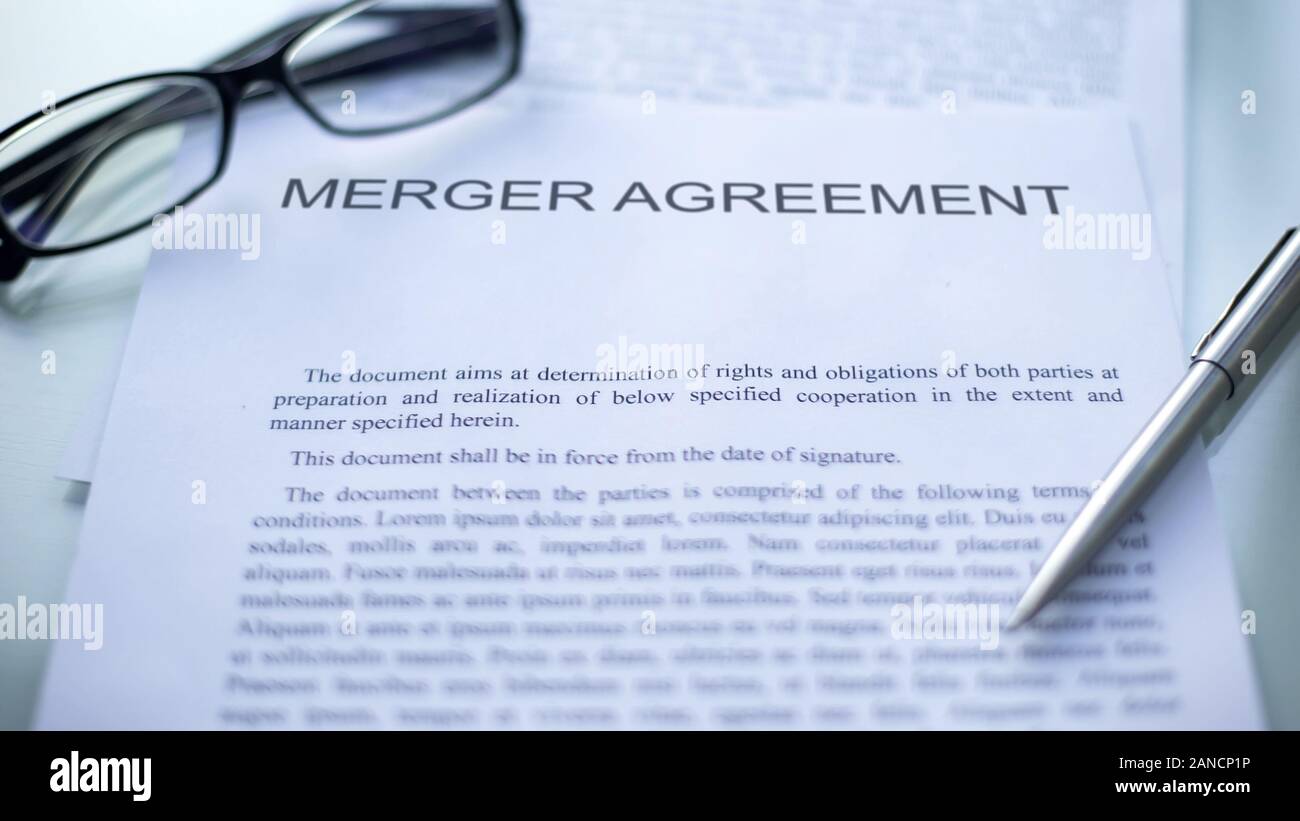 Merger agreement lying on table, pen and eyeglasses on official document Stock Photo