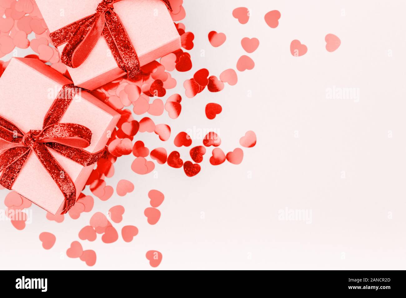 Craft boxes with red ribbon bow and glitter heart confetti. Valentine ...
