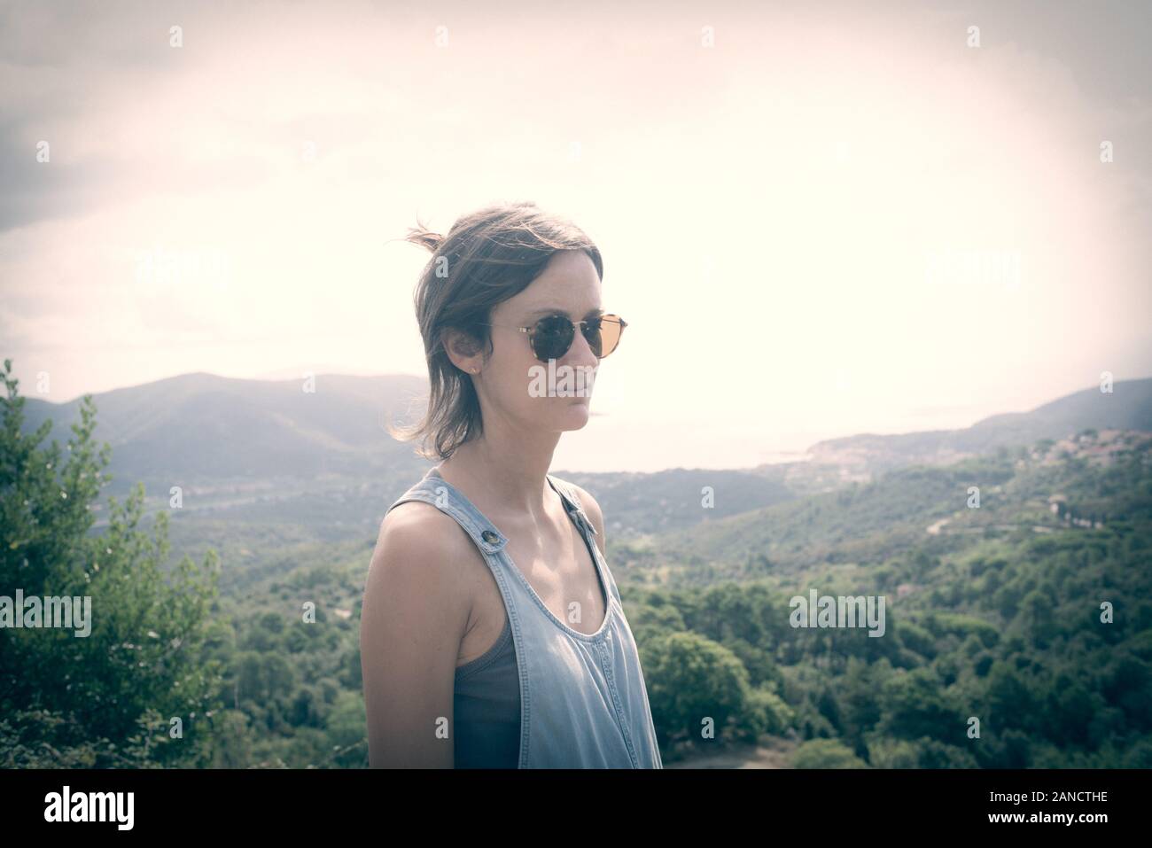 Young hipster woman wearing sunglasses admiring panorama. Matte finish Stock Photo