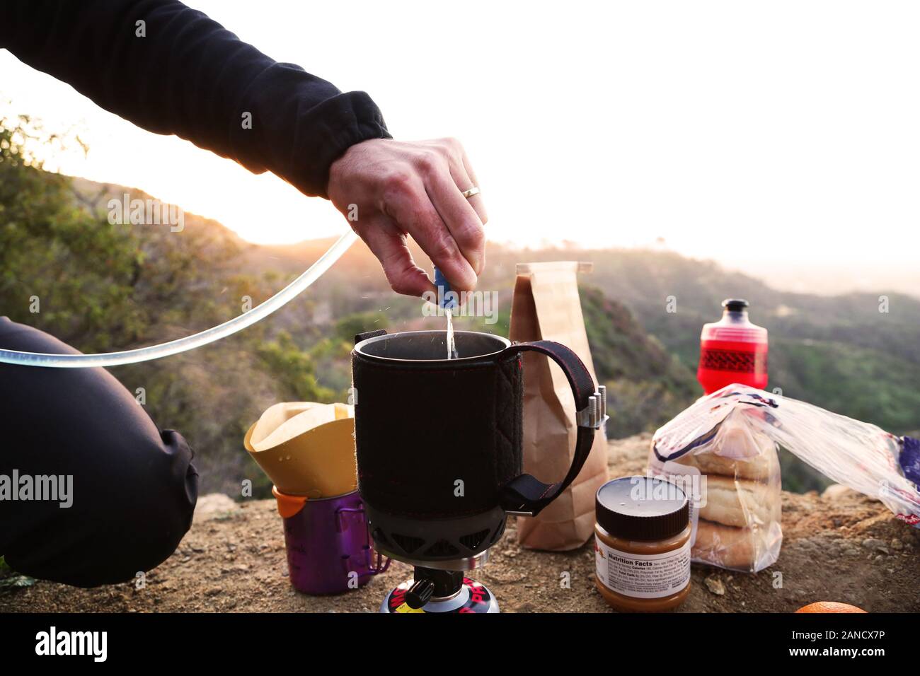 camper making coffee in mountains at sunrise Stock Photo Alamy