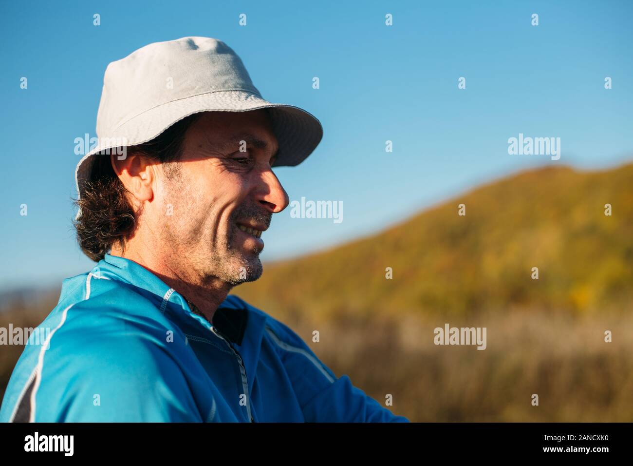 A profile shot of an older man. Autumn mountains background Stock Photo