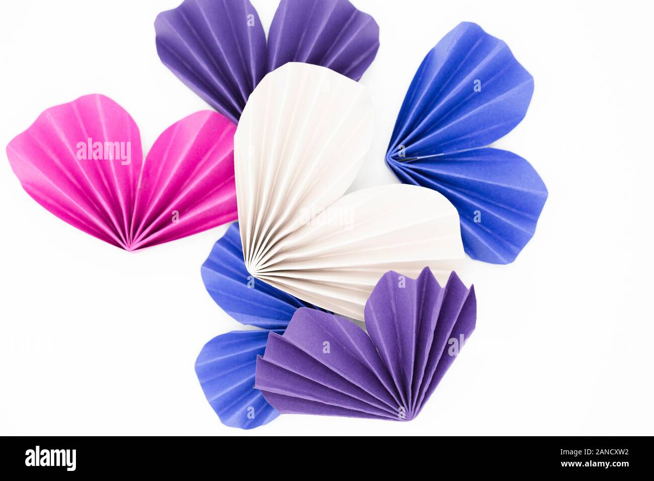 Origami hearts of various colors against white background Stock Photo