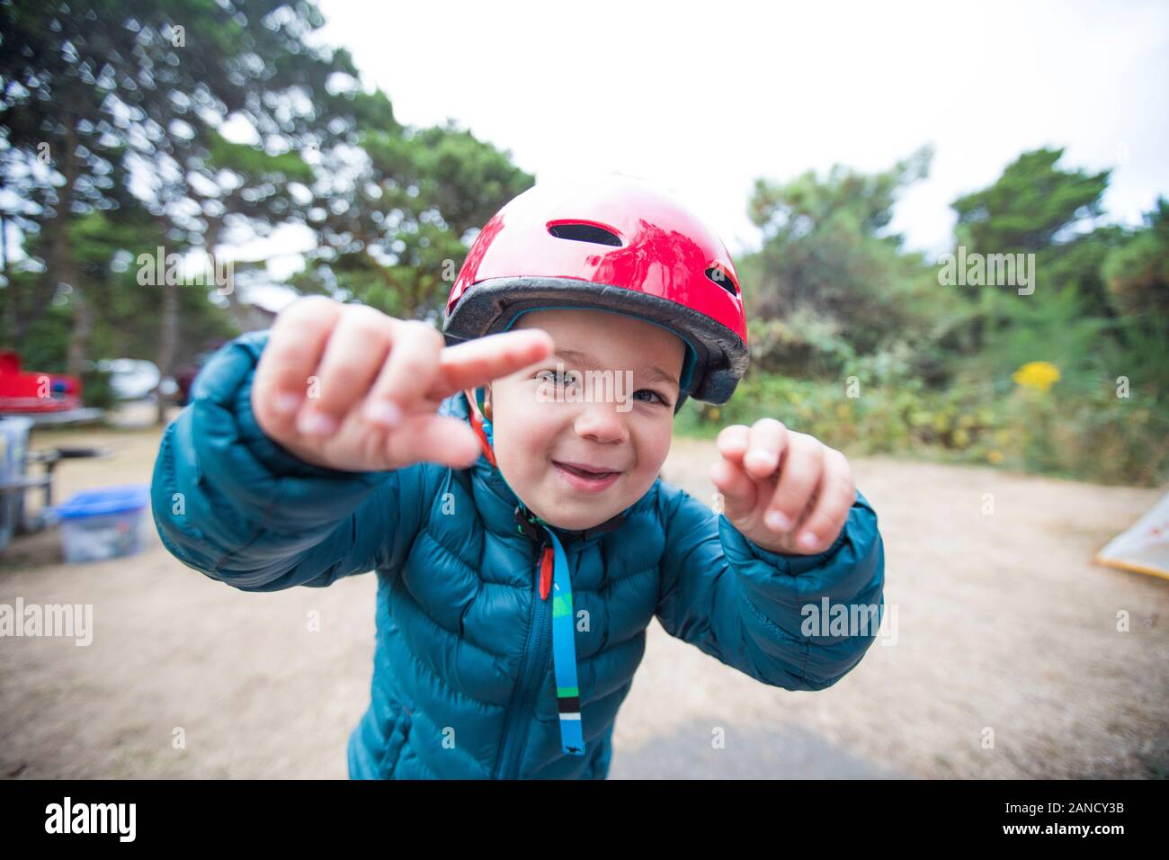 Toddler boy playing outdoors with helmet on. Stock Photo