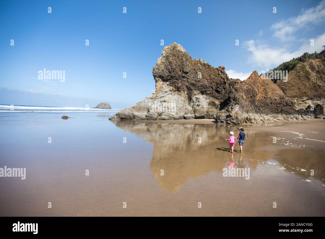 Brother and sister holding hands, walking on beach Stock Photo - Alamy