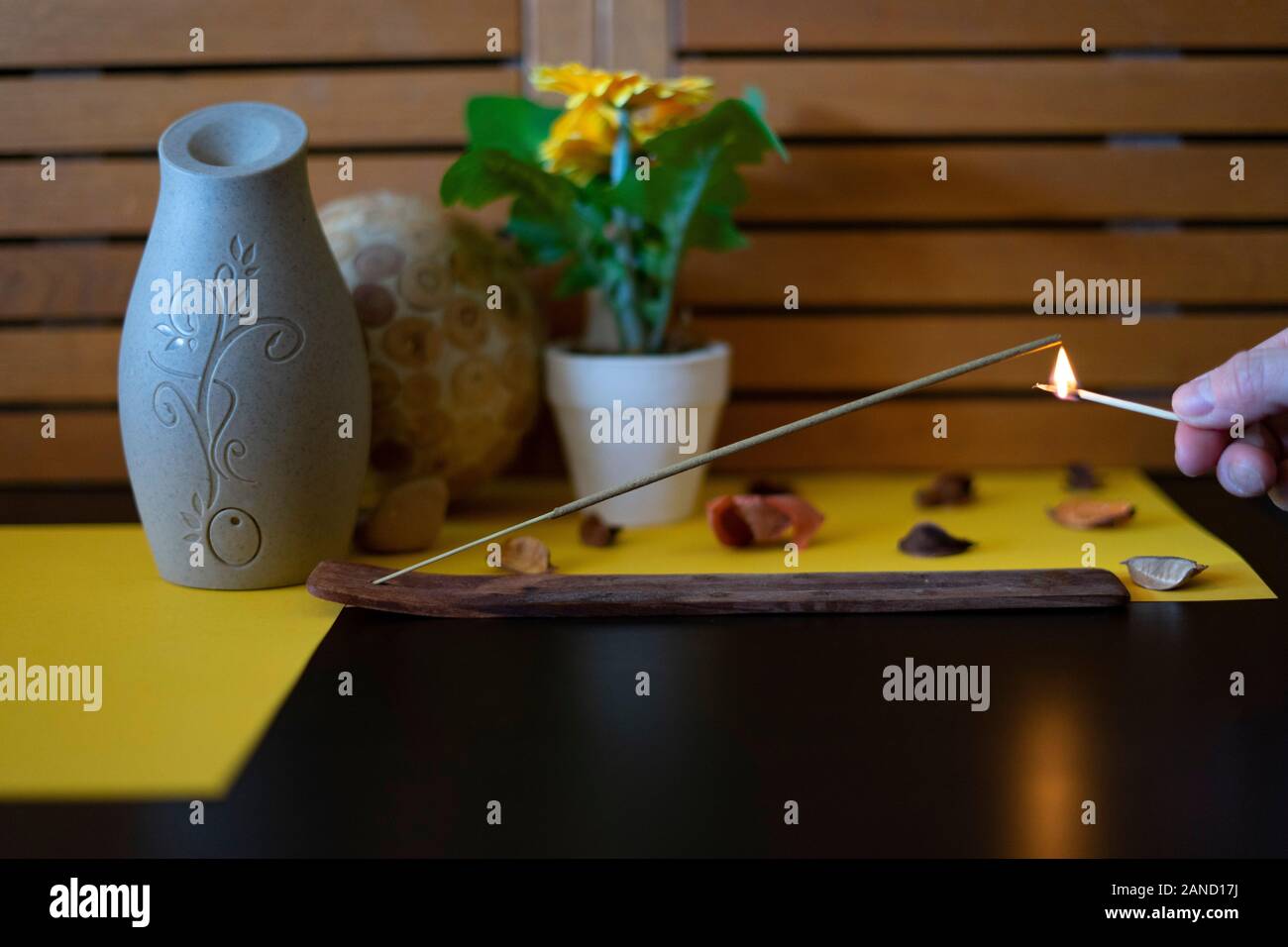 Hand lighting an incense stick with a match. Concept of incense Stock