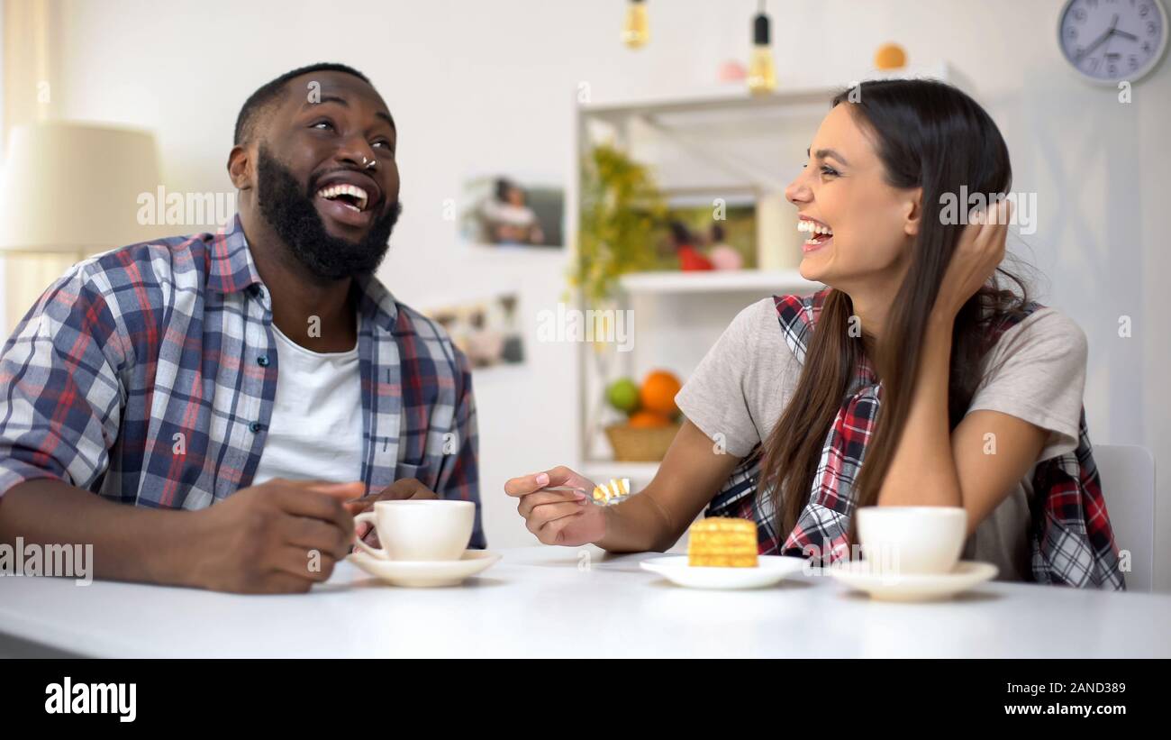 Laughing multiethnic family having lunch with cake, spending time together Stock Photo