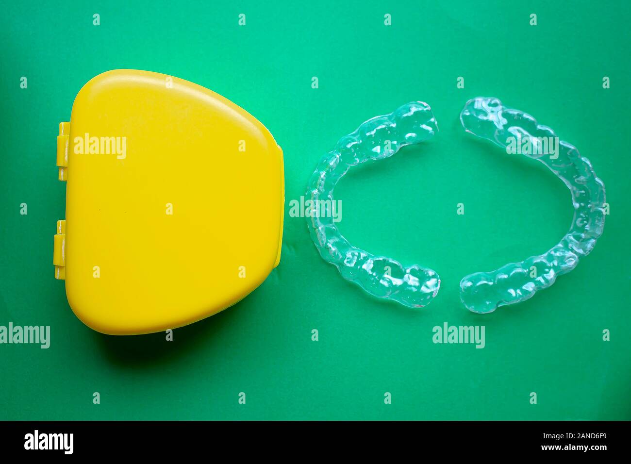 Mouth Guard with a yellow case on the right with green background Stock Photo