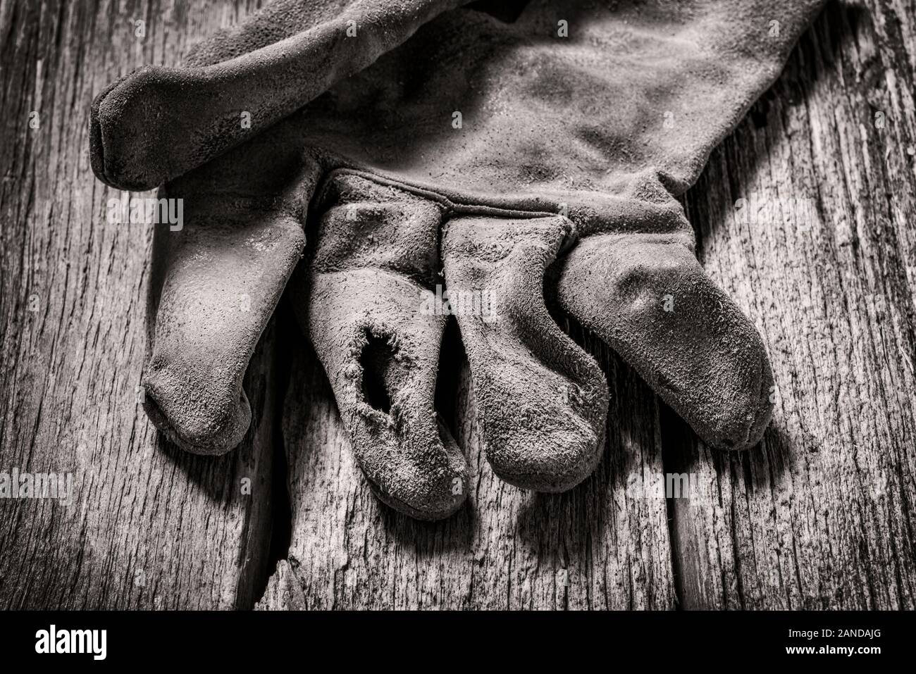 Black & white studio still life close-up of worn leather work gloves Stock Photo