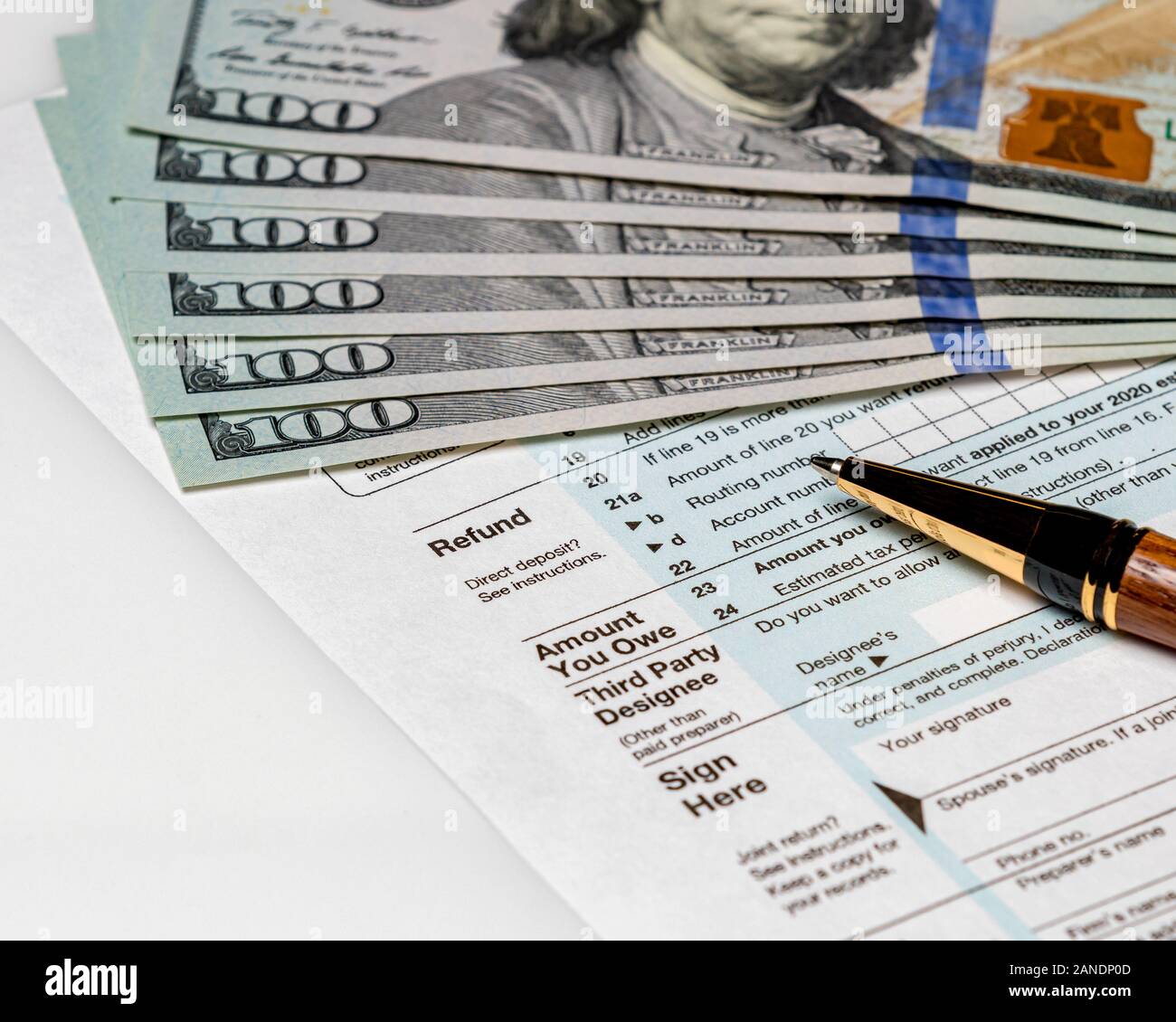 1040 individual income tax return form 2019 with pen and 100 dollar bills. Concept of filing taxes, payment, refund, and April 15,2020 deadline date. Stock Photo