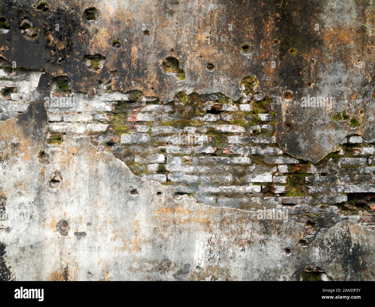 Grunge brickwork wall texture with moss render and bullet holes Stock Photo