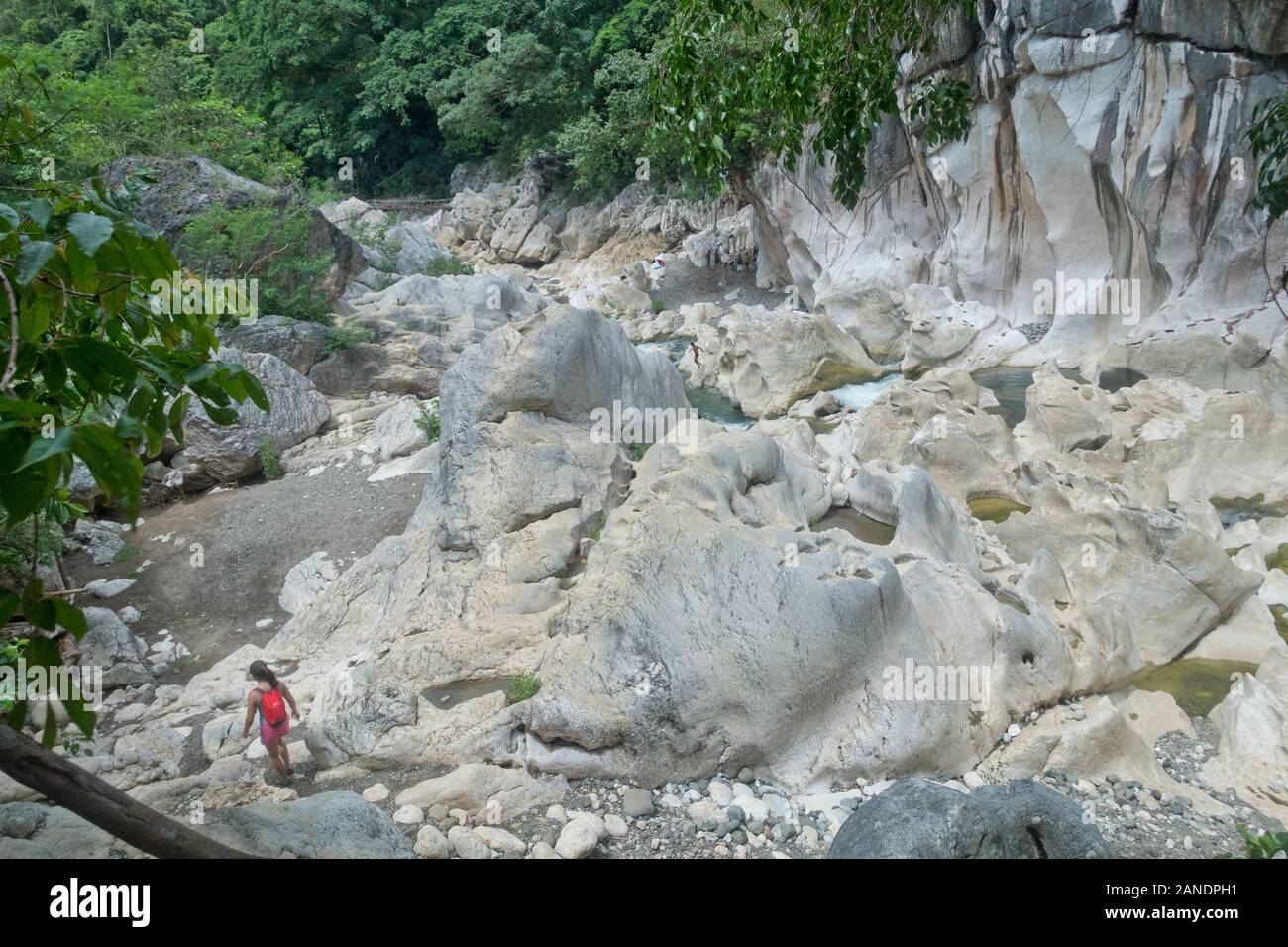 Tinipak River flows through mountainous terrain with rapids and cave with a natural swimming pool. Stock Photo