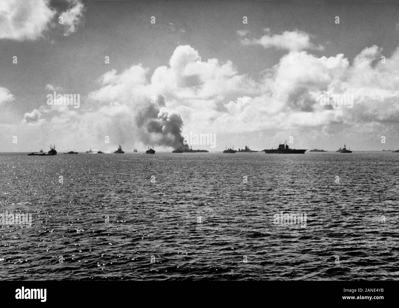 Bikini Atoll Atomic Bomb Tests, 1946: View of the target fleet immediately after the 'Able' aerial burst on 1 July 1946. The aircraft carrier USS Saratoga (CV-3) is in the center with USS Independence (CVL-22) burning at left-center. The ex-Japanese battleship Nagato is between them. Note the ship at left next to the battleship USS Pennsylvania (BB-38) trying to wash down the radioactivity with (contaminated) water from the lagoon. Stock Photo