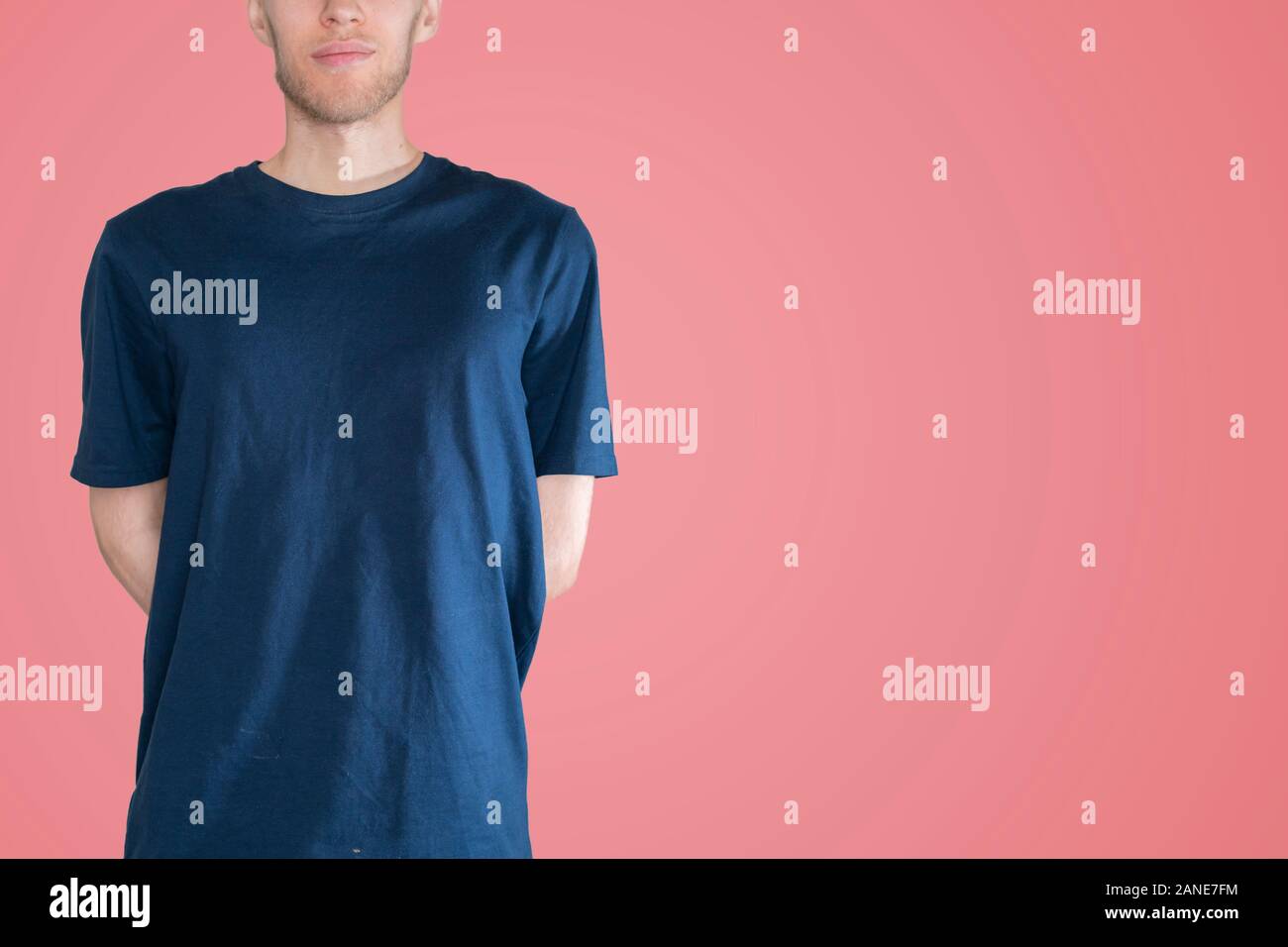 man in the dark blue t-shirt mockup and copy space against the color wall backround, no face Stock Photo