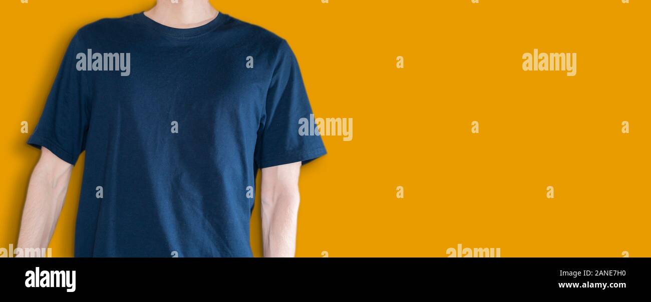 man in the dark blue t-shirt mockup and copy space against the color wall backround, no face Stock Photo