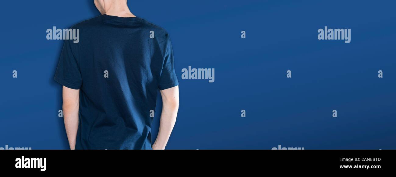 man in the dark blue t-shirt mockup and copy space against the color wall backround, no face Stock Photo