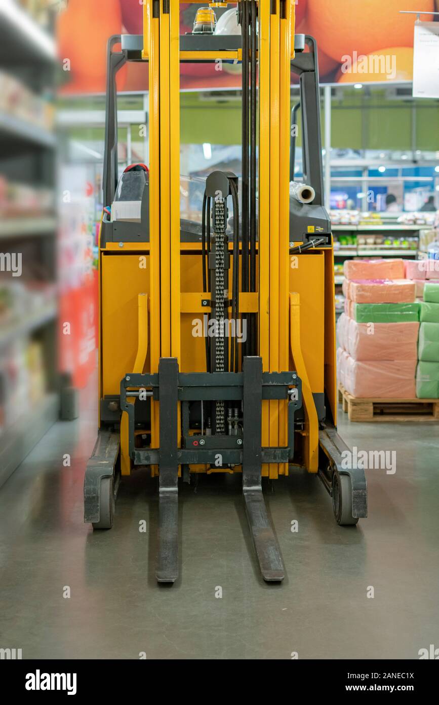 a forklift in the warehouse working and lifting the boxes of new