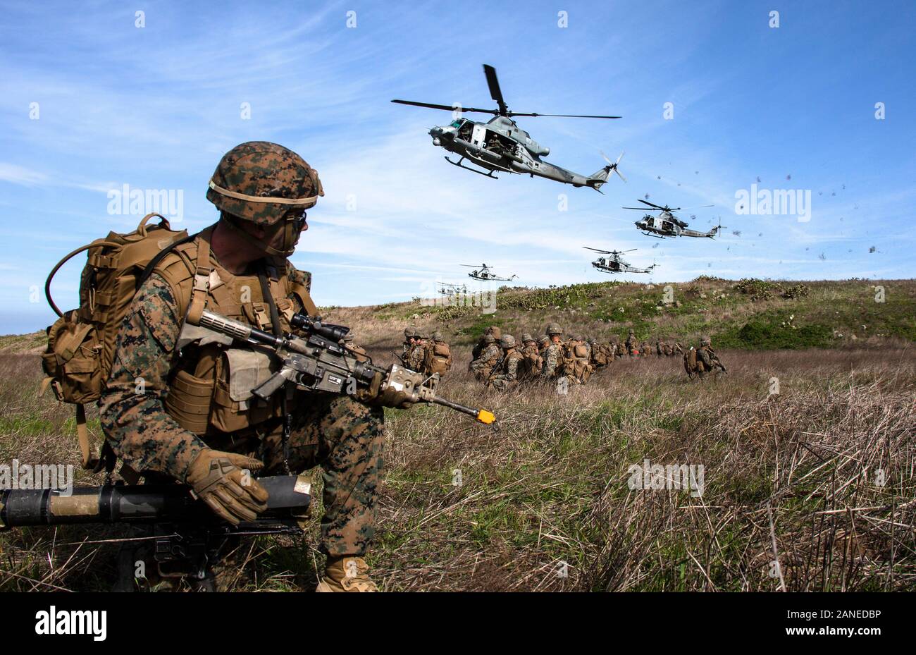 U.S. Marines with 2nd Battalion, 4th Marine Regiment, 1st Marine Division provide security for UH-1Y Venoms with Marine Light Attack Helicopter Squadron 469, Marine Aircraft Group 39, 3rd Marine Aircraft Wing, at a landing zone during Exercise Venom Storm on San Clemente Island, Calif., Jan. 15, 2020. Exercise Venom Storm demonstrated the Venom’s versatility in providing lethal options, whether operating from the sea or land. It’s ability to rapidly deploy from ship-to-shore, support ground forces with its own organic fire support and be armed and refueled at temporary sites is unmatched. The Stock Photo