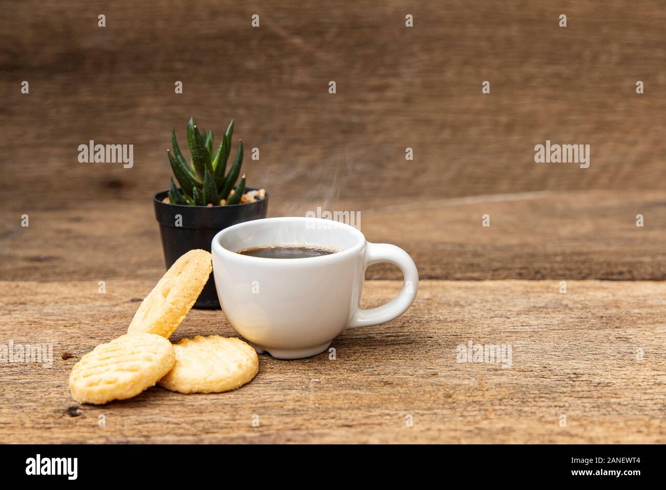 A white cup of coffee with cookie on the wooden table background. Stock Photo