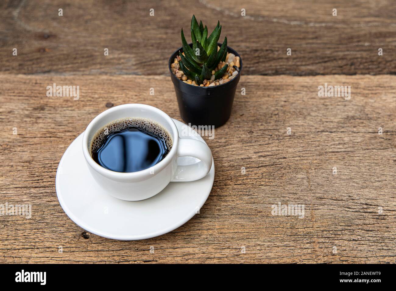 A white cup of coffee on the wooden table background. Stock Photo