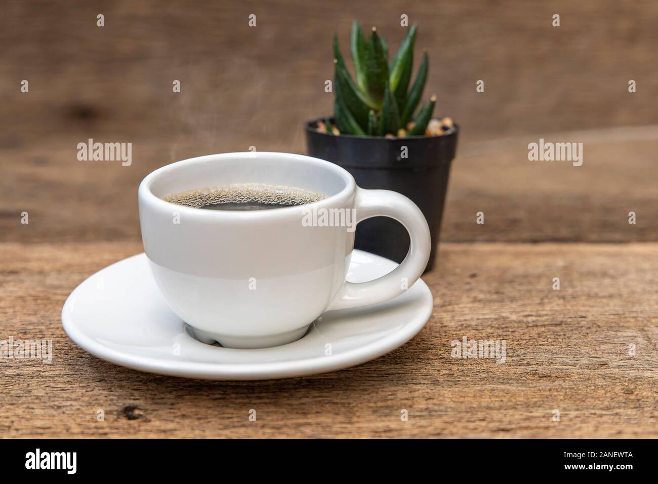 A white cup of coffee on the wooden table background. Stock Photo