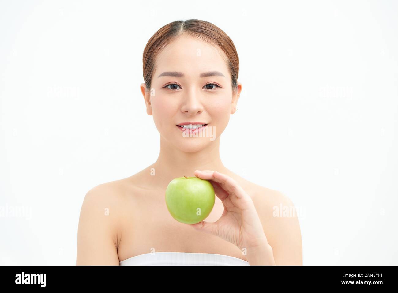 Smiling pretty model holding apple while posing on white background Stock Photo