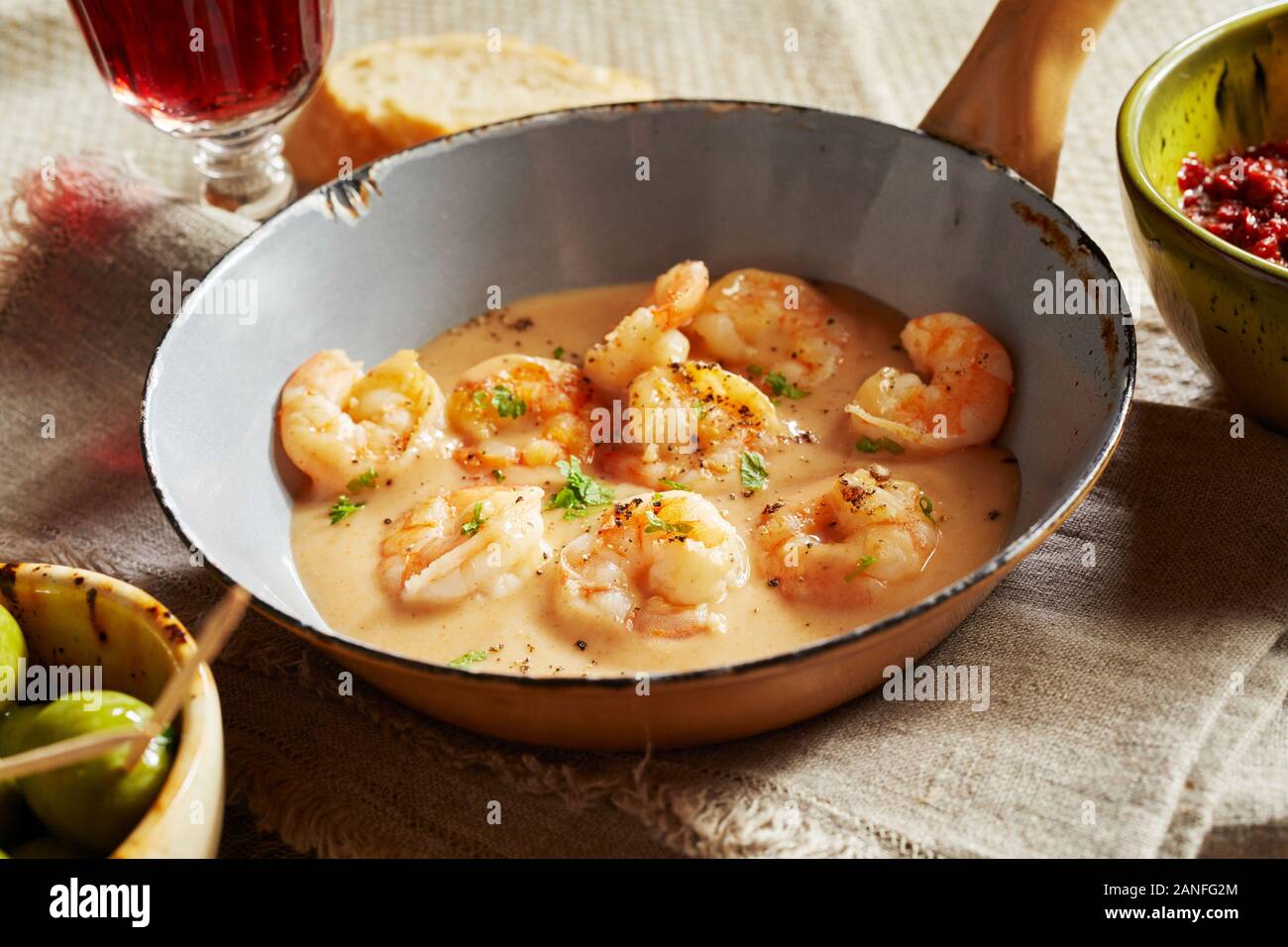 Scampi lobsters in cheese-cream sauce or kase sahne sauce served in an old small pan on linen towel in a restaurant with rustic style or country house Stock Photo