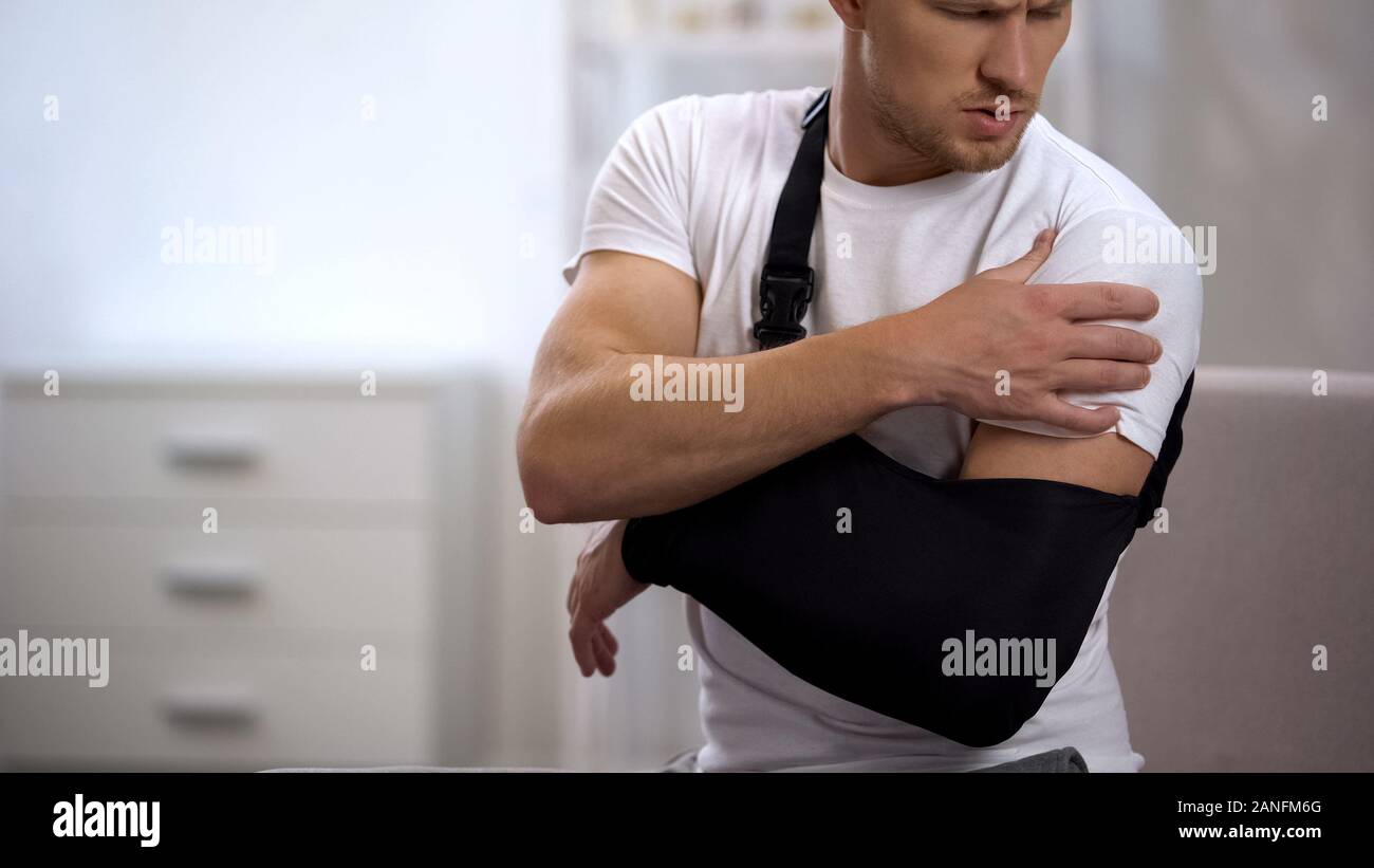 Man wearing arm sling feeling pain in shoulder, result of trauma