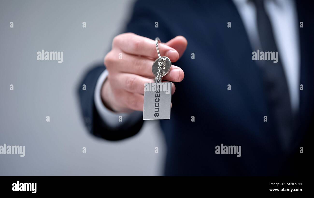 Success word on keychain in businessman hand, personal development courses Stock Photo