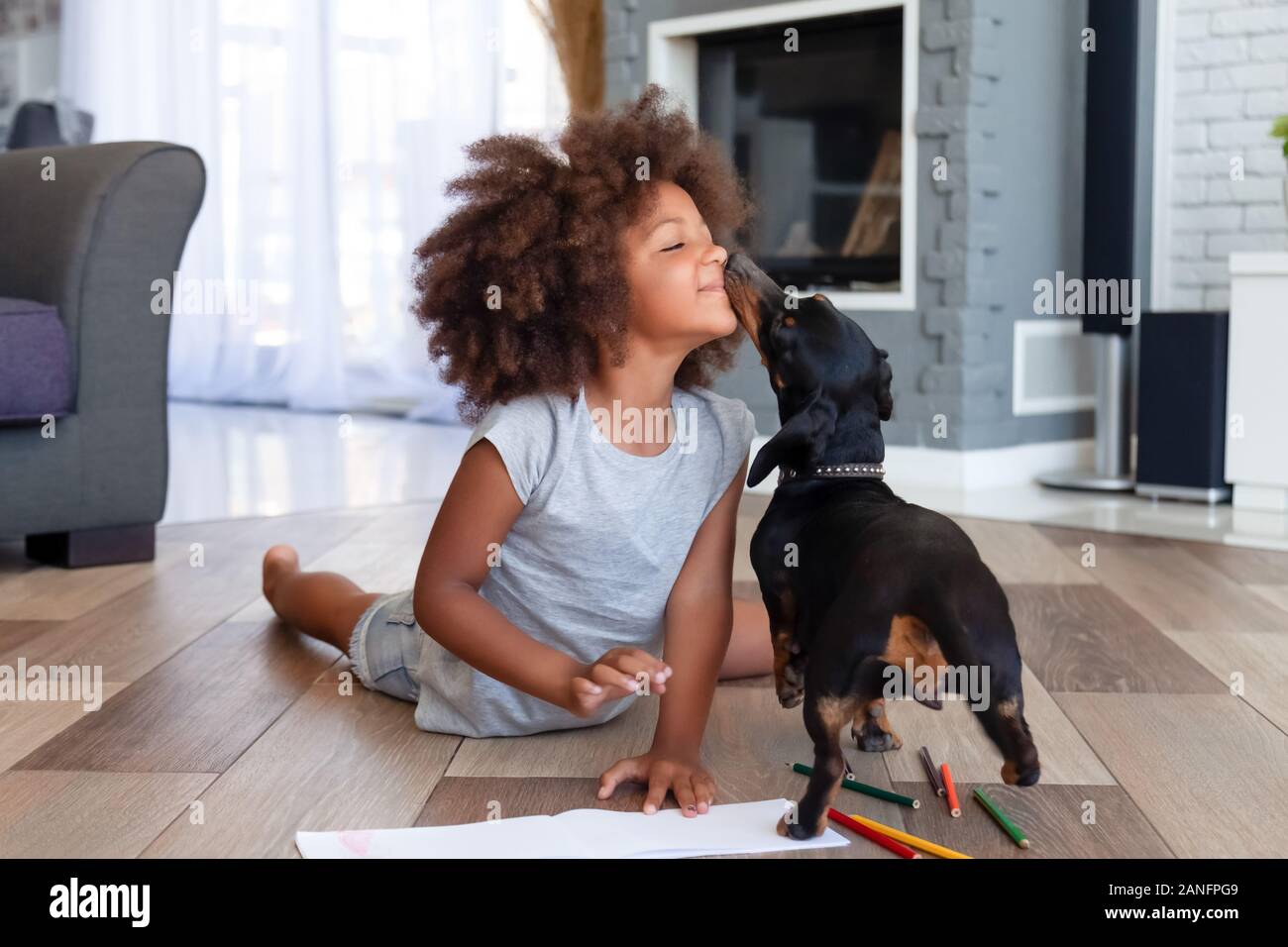 Cute little girl lying on floor playing with dog Stock Photo - Alamy
