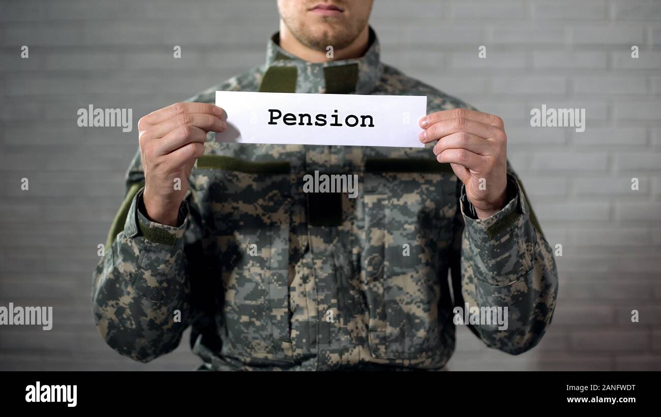 Pension word written on sign in hands of male soldier, retirement payments Stock Photo
