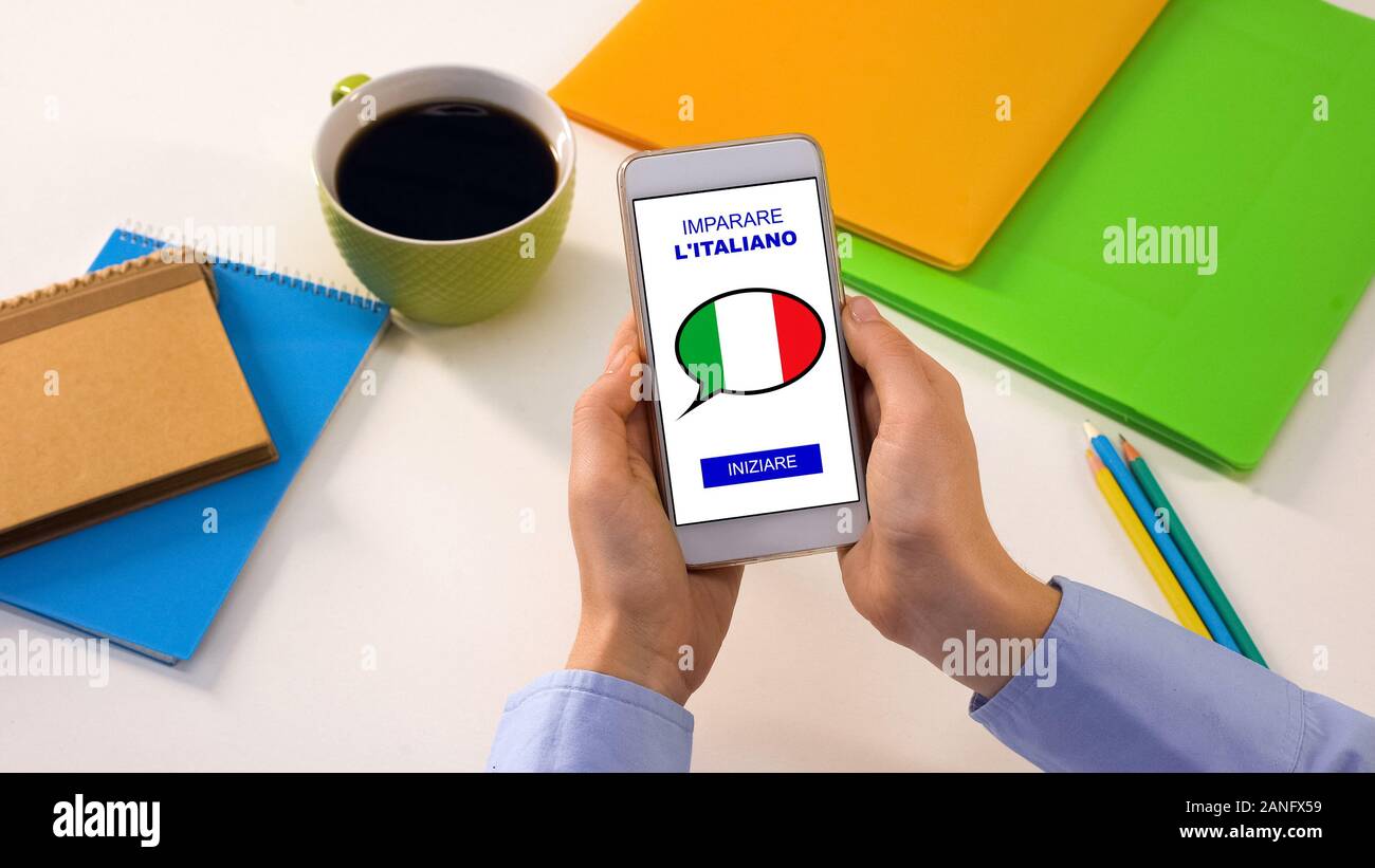 Italian language application on smartphone in persons hands, online