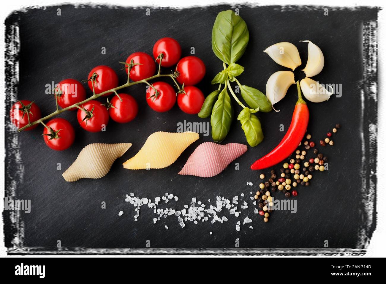 Pasta with vegetables ingredients on a black stone for an Italian pasta dish Stock Photo