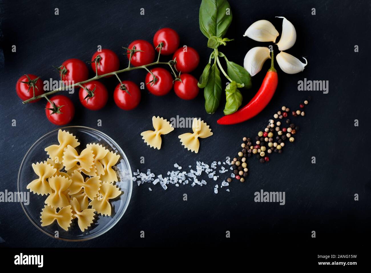 Pasta with vegetables ingredients on a black stone for an Italian pasta dish Stock Photo