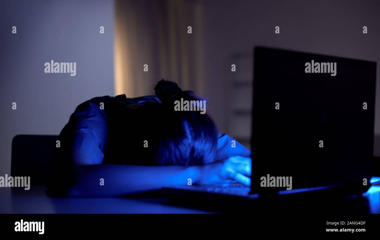 Exhausted freelancer fell asleep while working on computer, deadline concept Stock Photo