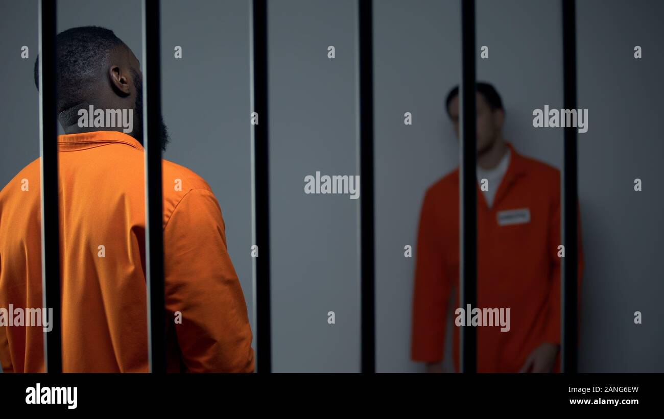 Inmates in prison cell looking at each other, misunderstanding and ...
