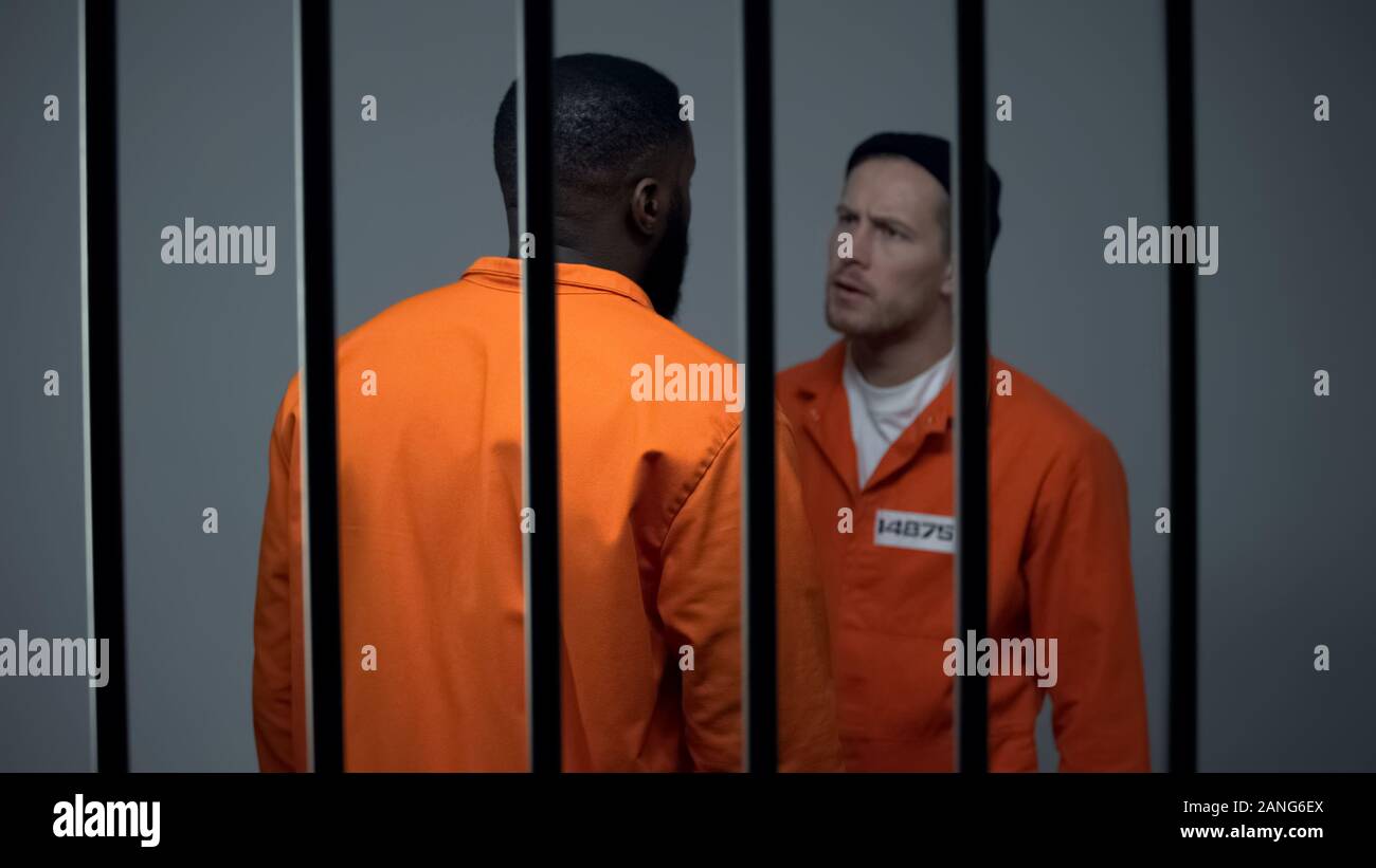 Afro-american and caucasian criminals quarreling in prison racial discrimination Stock Photo